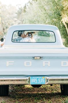 a bride and groom are in the back of an old ford truck