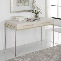 a white table with two drawers and a vase on it in front of a window