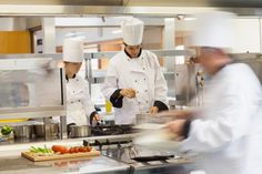 three chefs are in the kitchen preparing food