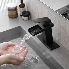 a person is washing their hands under a faucet