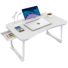 a white desk with a laptop on it and a cup of coffee next to it