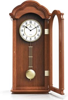 a wooden clock with an arched frame and pendulum