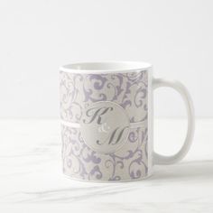 the monogrammed coffee mug is decorated with purple and white damaska designs