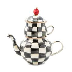 a black and white checkered teapot with a red rose on top, sitting in front of a white background