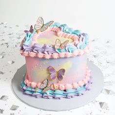 a pink and blue cake with butterflies on it