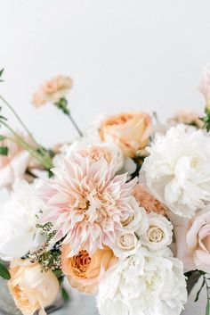 a vase filled with lots of white and pink flowers