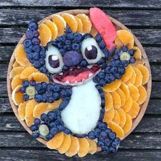 a cake made to look like a cartoon character with fruit on the face and eyes