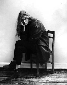 a black and white photo of a woman sitting on a chair