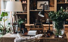 a living room filled with lots of furniture and plants on top of a wooden table