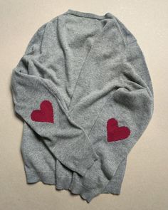 two sweaters with red hearts on them