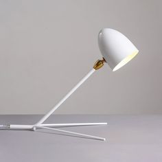 a white and gold lamp on a gray surface