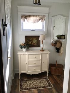 a white dresser sitting in the corner of a room