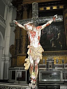 the crucifix is in front of an ornate painting