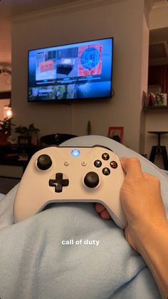 a person holding a video game controller in front of a tv