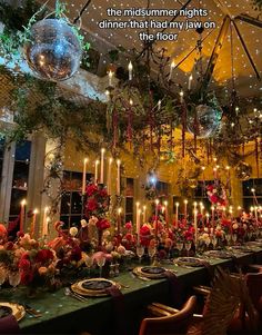 a long table is set with candles, flowers and other decorations in front of a disco ball