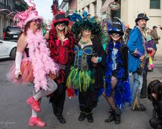 some people are dressed up and posing for a photo on the street while others watch