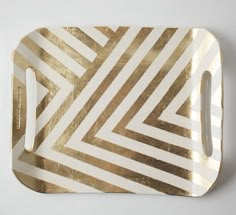 a gold and white serving tray with lines on it