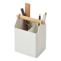 a pen holder with pencils, scissors and other office supplies in it on a white background