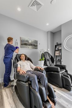 a man is getting his hair cut by a woman in a reclining chair at the barbershop