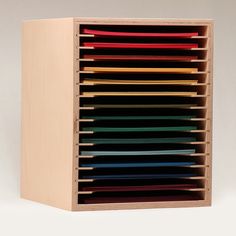 a wooden cabinet filled with lots of different colored folders on top of each other