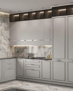 a kitchen with marble counter tops and white cabinets