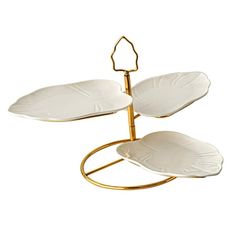 three white plates on a gold stand