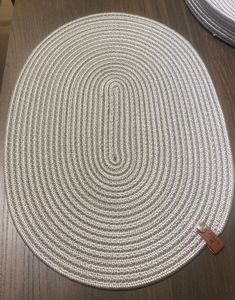 two round rugs sitting on top of a wooden table next to a bottle opener