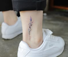 a woman's foot with a small flower tattoo on the left side of her ankle