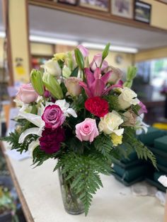 a vase filled with lots of different colored flowers