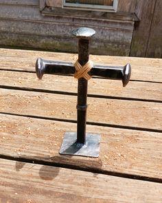 a metal cross sitting on top of a wooden table