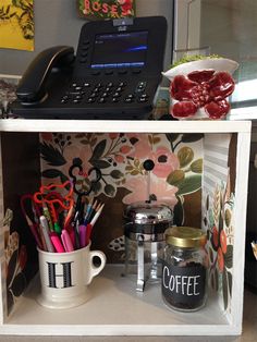 there are two shelves with different items on them, one has a phone and the other has coffee mugs