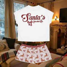 🧸Why choose between comfort and style when you can have both? This Christmas-themed "Santa's Favorite" pajama set is the perfect addition to your holiday wardrobe. Designed with a relaxed fit, this women's short two-piece set features a ribbed collar and no sleeve seams, ensuring maximum comfort. Made from 95% polyester and 5% spandex, the fabric offers a cozy feel with just the right amount of stretch. The seam thread color is carefully matched to the design, and the set includes a sewn-in lab Christmas Pajamas Shorts, Cozy Homewear, Short Sleeve Christmas Pajamas, Christmas Pajama Shorts, Pajamas Shorts, Sleep Shorts, Holiday Wardrobe, Pajama Robe, Authentic Design