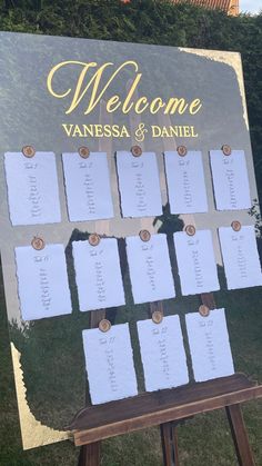 a sign that has been set up for a wedding with seating cards attached to it