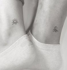 two people with matching tattoos on their feet, one is holding the other's leg