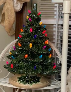 a small green christmas tree on a white shelf