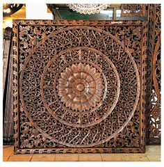 an intricately carved wooden panel in the shape of a flower on display at a store