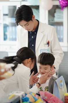 a man standing next to two children at a table