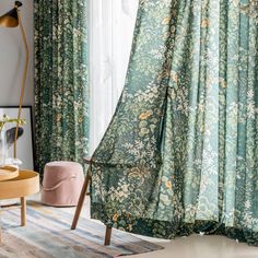 a living room with green curtains and floral print on the drapes in front of a window