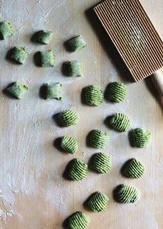 some green cookies are on a table next to a spatula