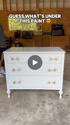 a white dresser with gold knobs on it and the words guess what's under this paint