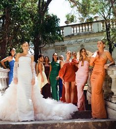 several women in dresses standing on steps with one woman wearing a dress and the other is holding