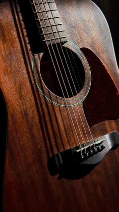 an acoustic guitar sitting on top of a wooden table