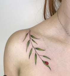 a ladybug tattoo on the back of a woman's shoulder and chest