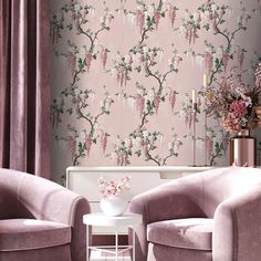 two chairs and a table in front of a wallpapered room with pink flowers