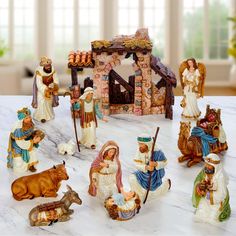 a group of figurines sitting on top of a table next to a nativity scene