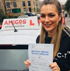 a woman holding up a driving test pass