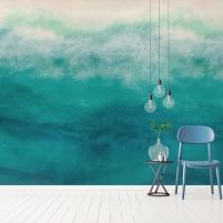 a chair and table in front of a wall with an ocean scene painted on it