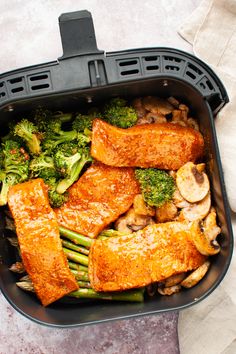 a dish with broccoli, mushrooms and tofu in it on a table