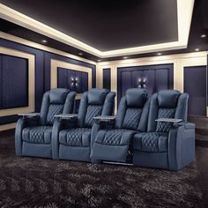 an empty theater room with blue leather seats and black carpeted flooring on the walls