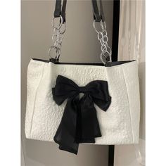 Step into the world of girly charm with our "Coquette Bow Shoulder Bag." This large shoulder bag epitomizes the coquette aesthetic with its simple yet undeniably cute design. Featuring a sleek white exterior accented by a striking black bow at the center, it’s a statement piece that effortlessly blends femininity with a touch of edgy sophistication, thanks to the chain detail on the straps. Designed for the fashion-forward individual who loves to express their unique style, this bag is not just Shoulder Bag Aesthetic, My Style Bags, Sac Diy, Bow Bag, Girly Bags, Crossbody Bags For Women, Fancy Bags, Bags Aesthetic, Chic Bags